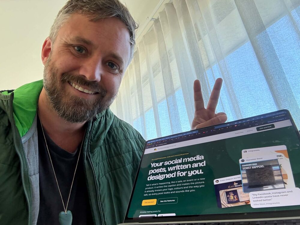 Tim giving a peace sign beside a laptop open on the YourCommunityYourBrand home page.